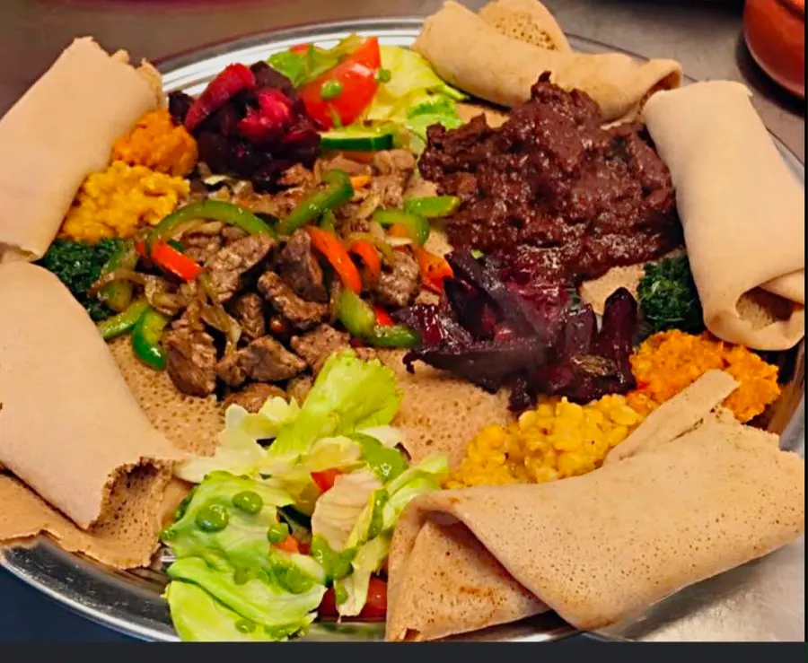 Tibs met groenten, geserveerd met injera